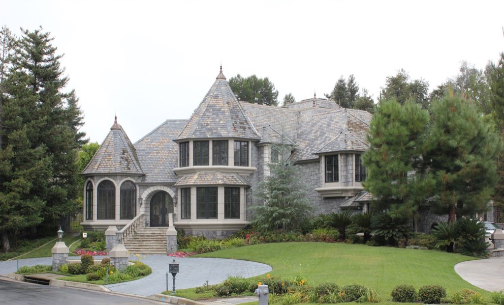 Stone chateau with turrets and slate roof set among redwoods