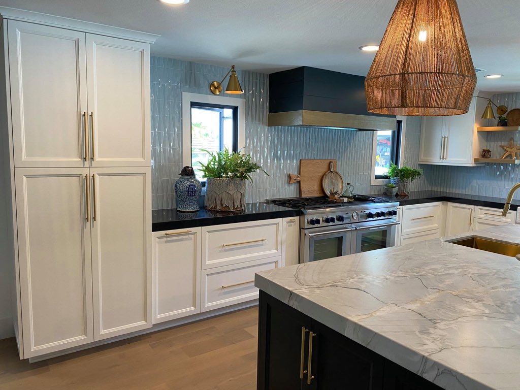 White shaker kitchen with brass hardware, textured tile backsplash and a woven pendant